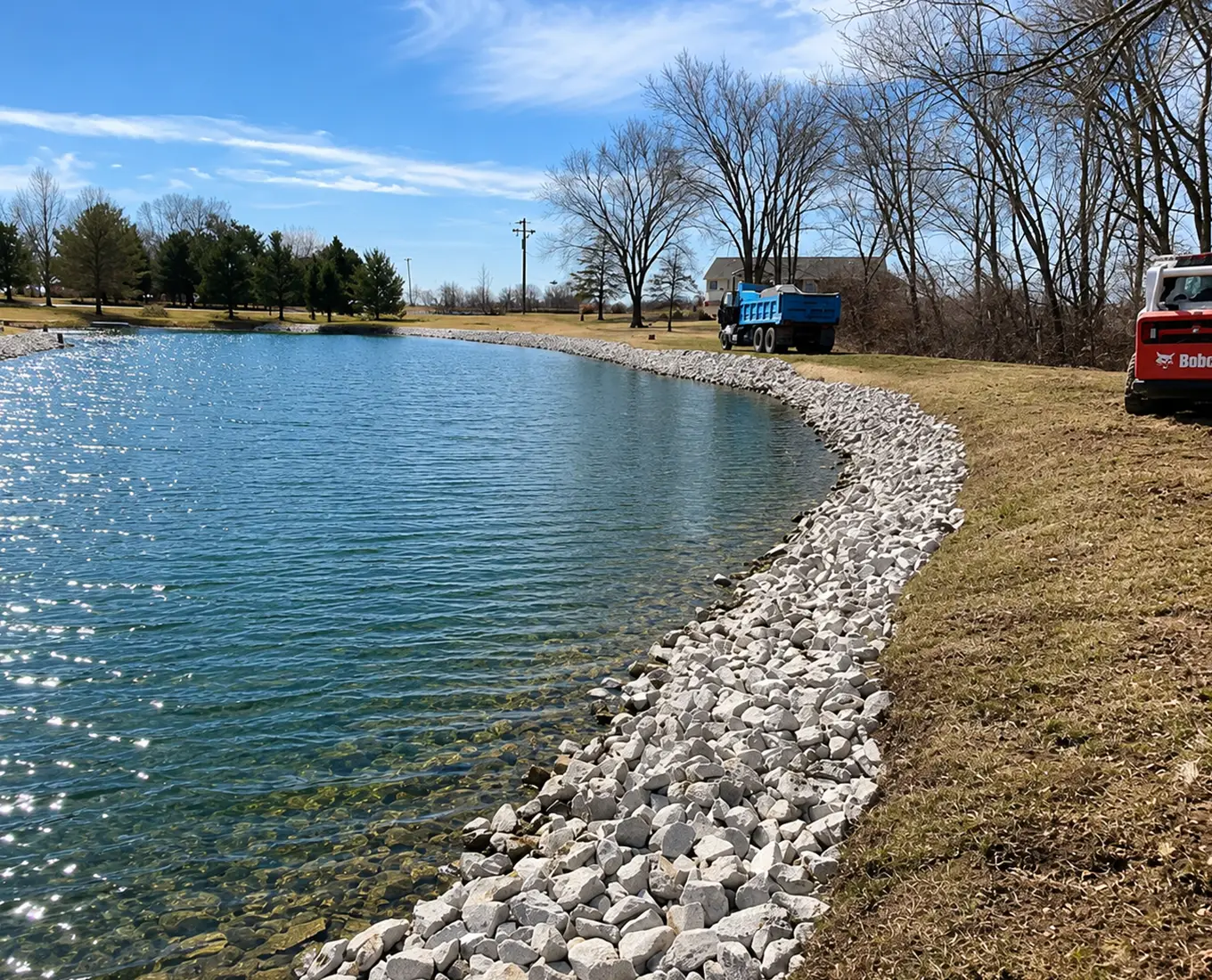 Pond excavation and shoreline rock installation in Columbia, Illinois improving erosion control and pond appearance.