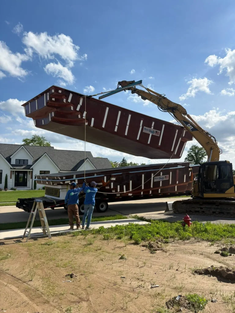 River Pools fiberglass pool installation using excavator and crane equipment at a residential property in Columbia, IL.