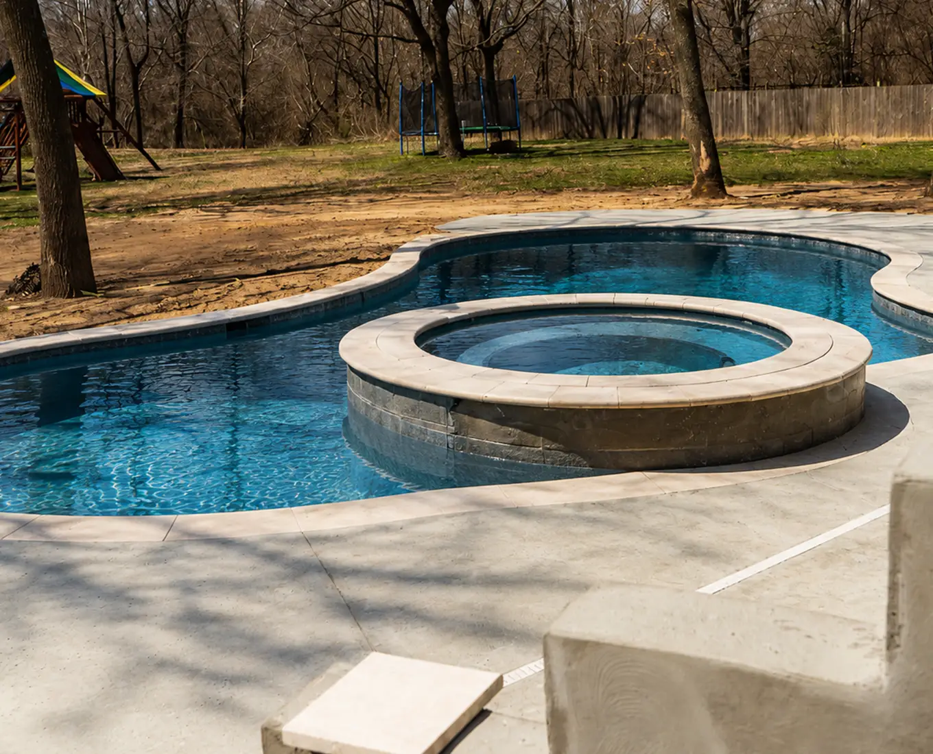 Gunite pool and raised spa combination with expansive patio space and premium outdoor amenities in Smithton, IL.