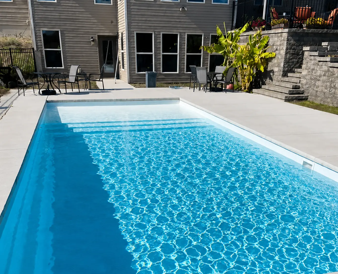 Modern rectangular swimming pool with tanning ledge, clean design, and premium outdoor aesthetics in Waterloo, IL.