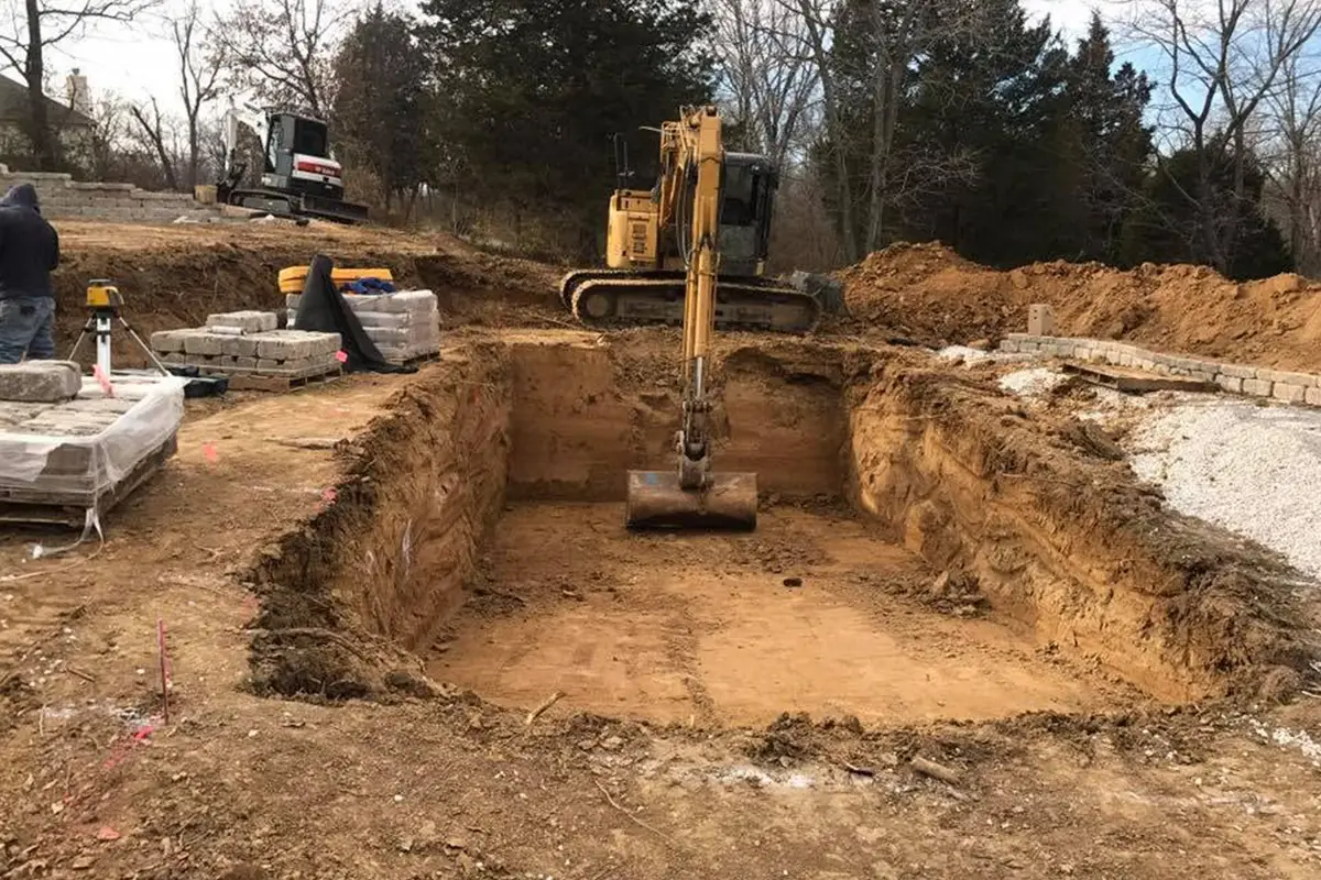 Excavator digging a pool foundation at a residential property in Columbia, IL.
