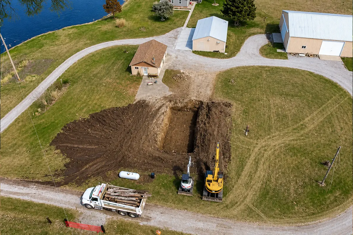 Aerial view of excavators digging a large foundation near a pond in Columbia, IL.